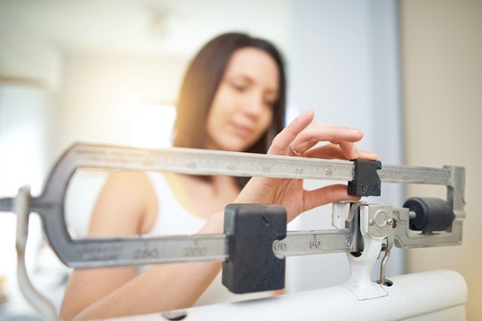 woman on scale managing weight