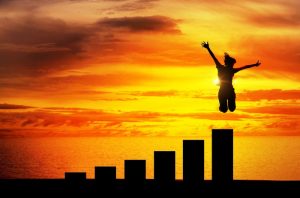 woman jumping for joy above growth chart