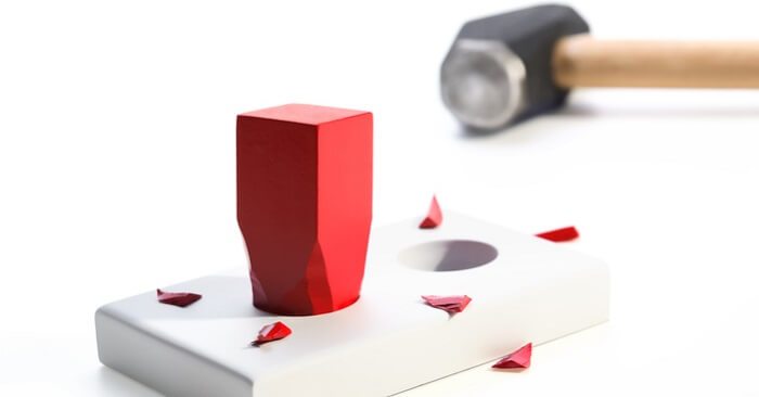 Hammer and square peg forced into a round hole