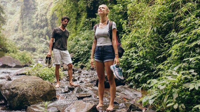 Couple on forest hike walking by a creek