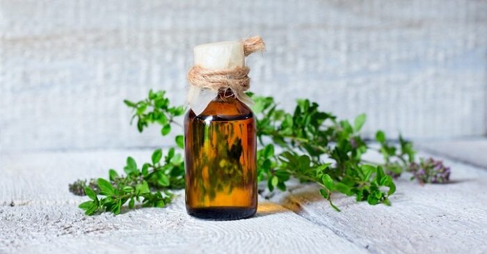 thyme essential oil bottle and herb