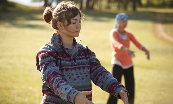two women practicing qigong in park