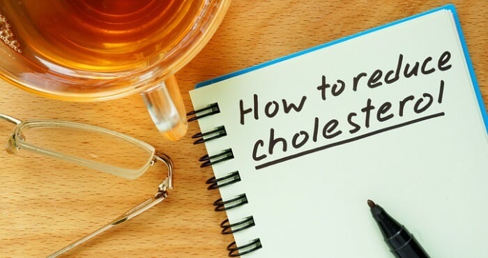 Notepad and pen with How to Lower Your Cholesterol