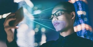 businessman looking at smartphone - facial recognition concept