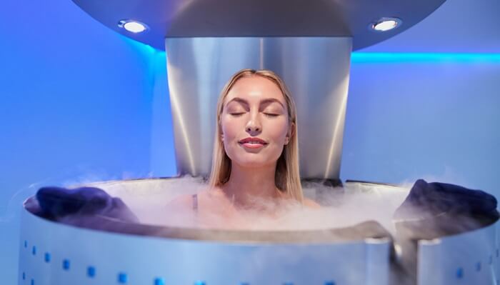Young woman in a whole body cryotherapy cabin