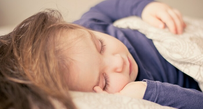 little girl sleeping in bed