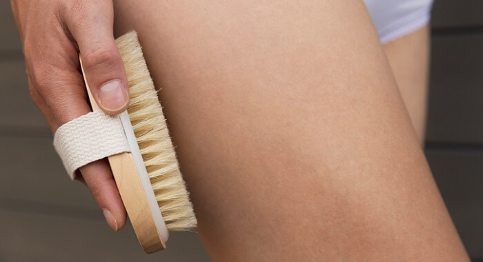 woman dry skin brushing her leg