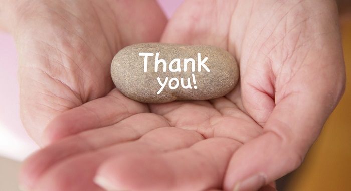 gratitude exercises - close up up woman's hands with "thank you" rock