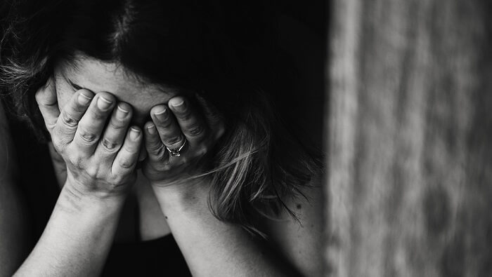 grieving woman with hands covering face