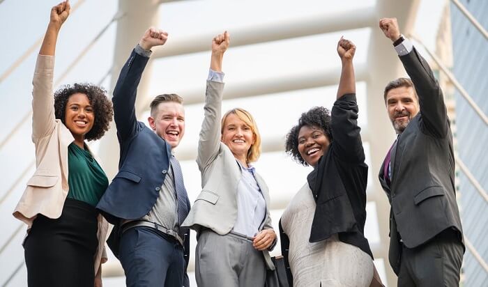 group of happy business people with arms raised