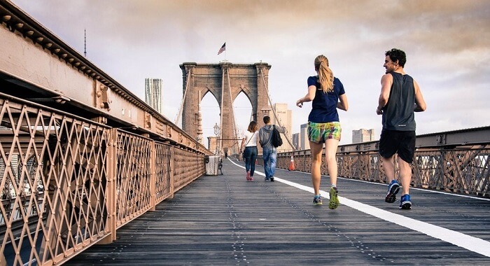 young couple jogging on bridge