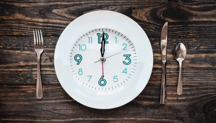 intermittent fasting time concept with clock on plate