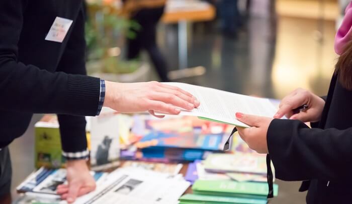 man sharing info with woman at exhibition stand
