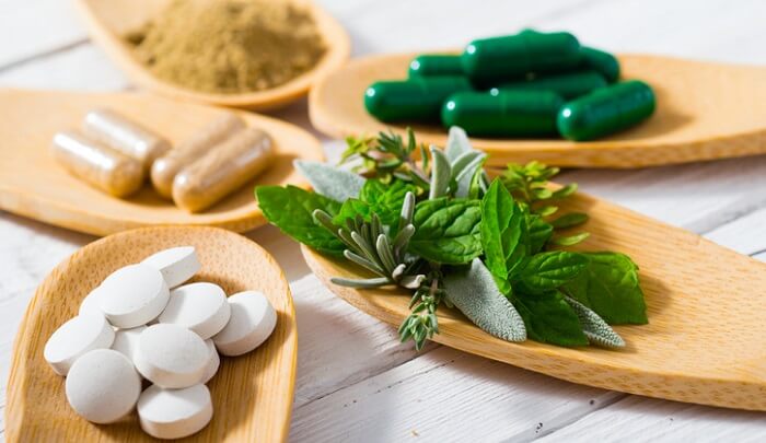 holistic solutions concept - various herbs and supplements on spoons