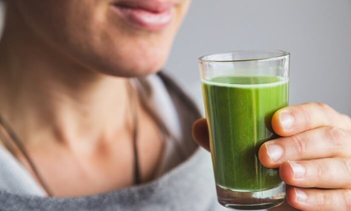 woman drinking green drink
