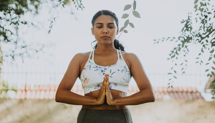 woman meditating by trees