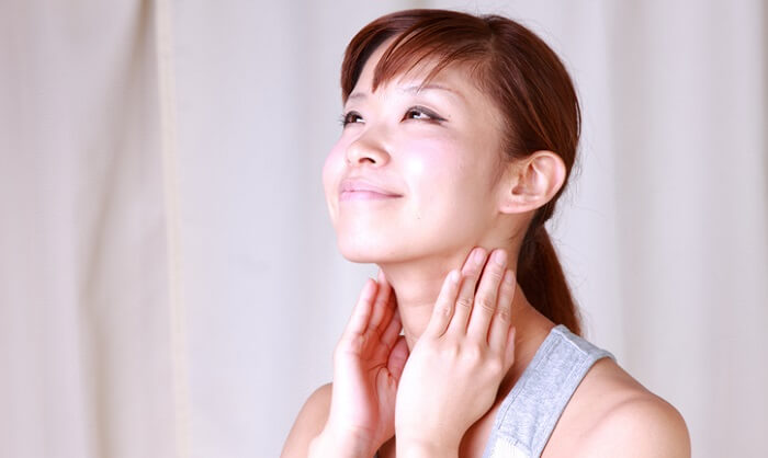 young japanese woman massaging her neck