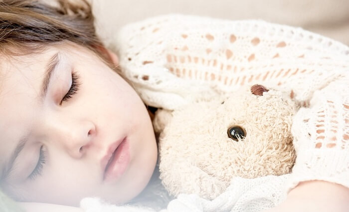 little girl napping with teddy bear