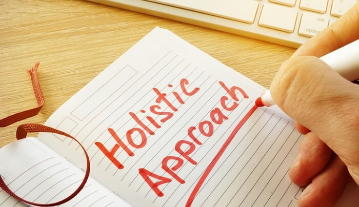 hand writing "holistic approach" on paper