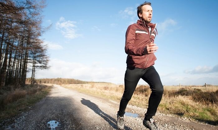 middle-aged man running on a trail
