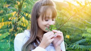 happy young woman smelling mint - herbs for lung health concept
