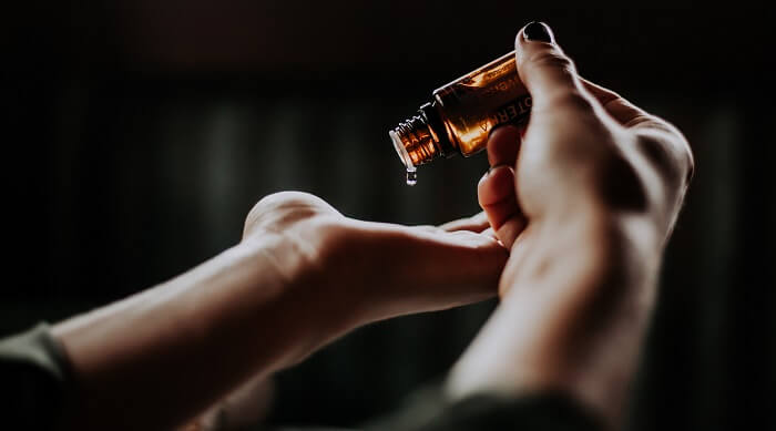 dropping essential oil onto palm