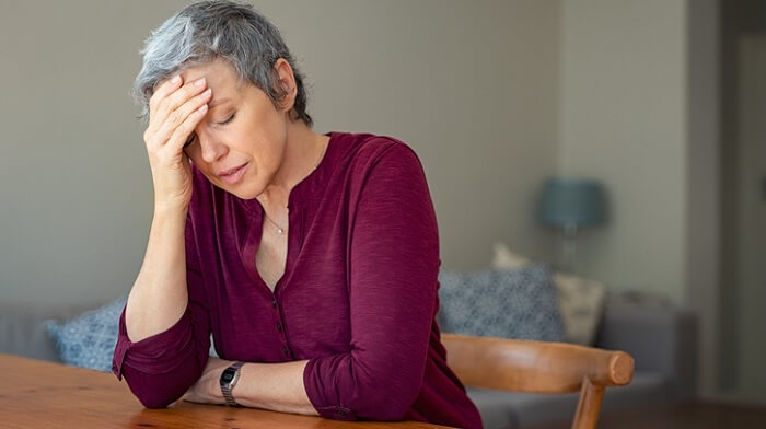 stressed senior woman with hand on forehead
