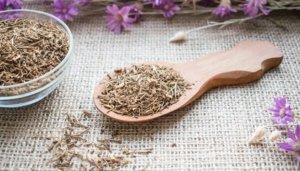 valerian flowers and roots on on wooden spoon