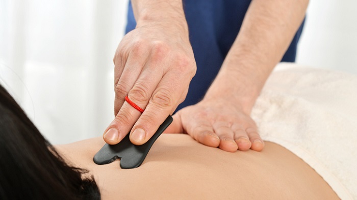 acupuncture tools - gua sha treatment on patient's back