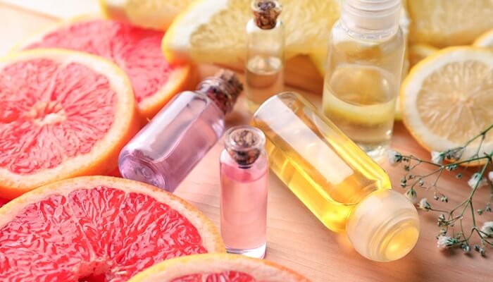 bottles of essential oils for detoxing heavy metals next to lemon and grapefruit slices