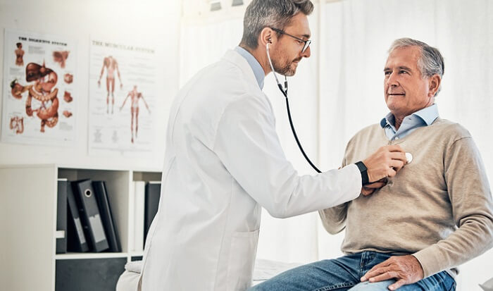 doctor listening to senior patient's heartbeat