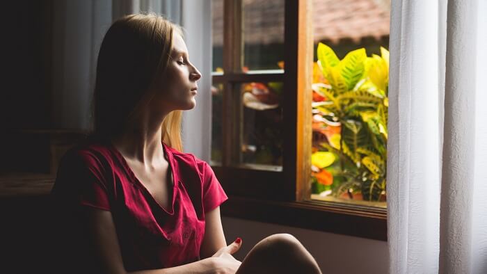 relaxed young woman looking out window