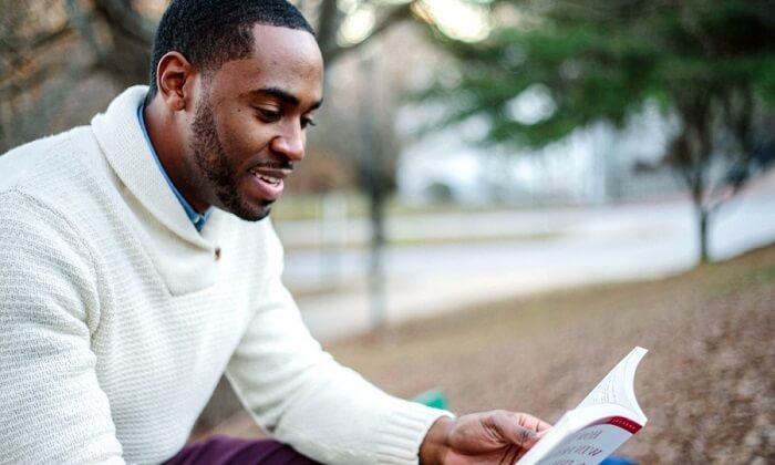 happy man reading book in park
