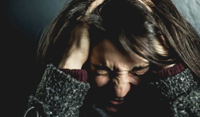 young stressed out woman with hands holding head