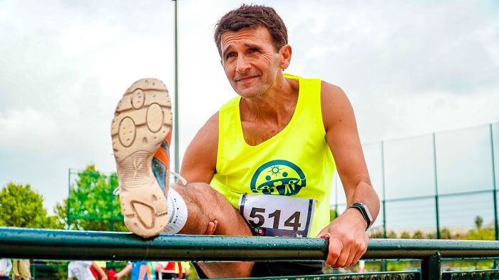 middle age man stretching for race