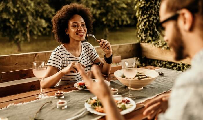 man and woman dining outside in evening
