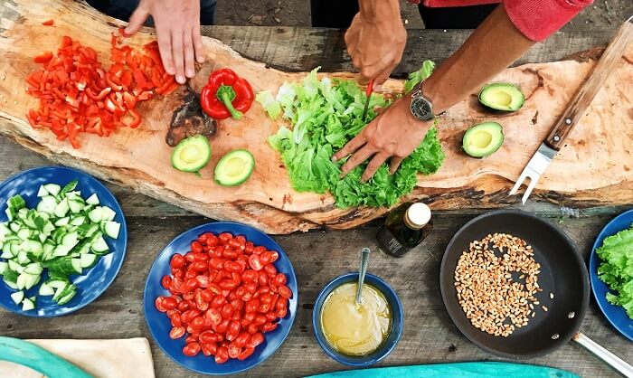 man preparing vegetables and spices for a meal