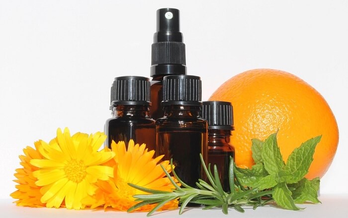 orange essential oils bottles next to orange