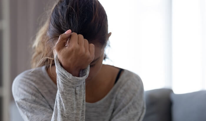 distraught young woman with hand on forehead