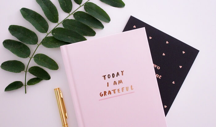 gratitude journal next to pen and leaves