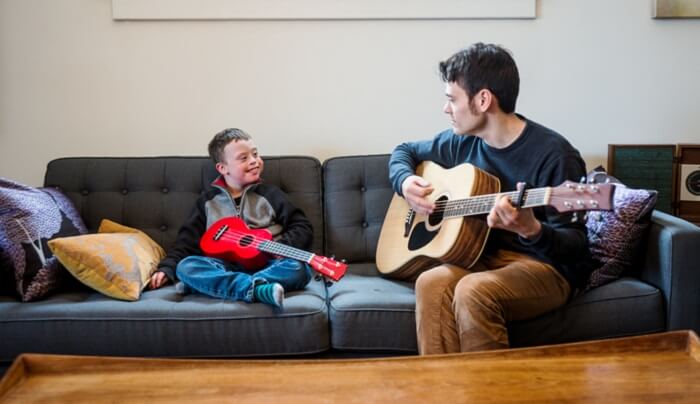 music therapist and child playing guitar