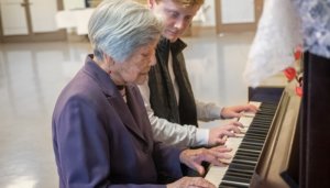 music therapist playing piano with senior patient