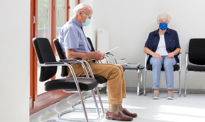 senior man and woman in doctor's office waiting room