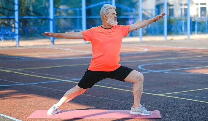 senior man doing yoga in park