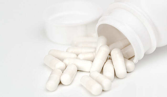 white vitamin k2 pills on white background