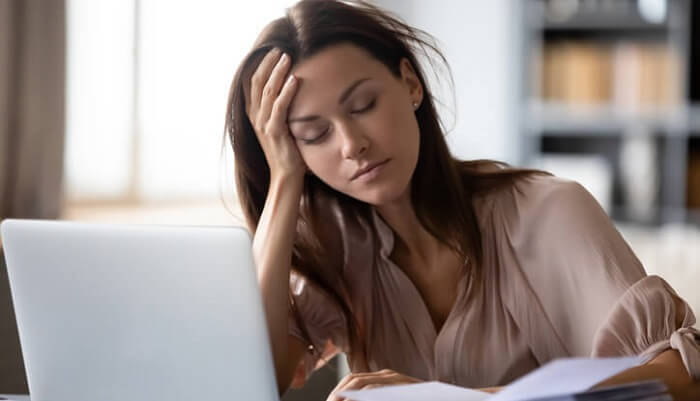 young woman with low energy on laptop