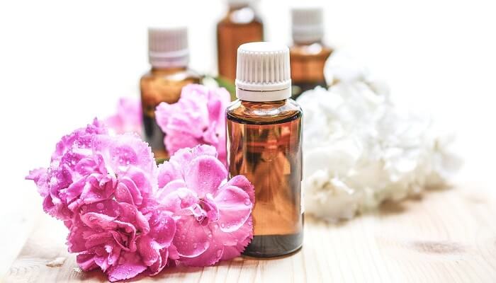 flowers next to essential oil bottles