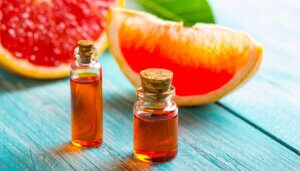 sliced grapefruit and essential oil bottles on wooden background