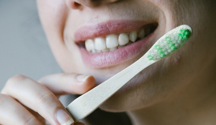 smiling young woman with toothbrush
