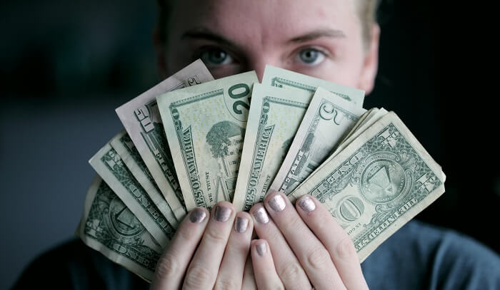 woman showing cash in front of face